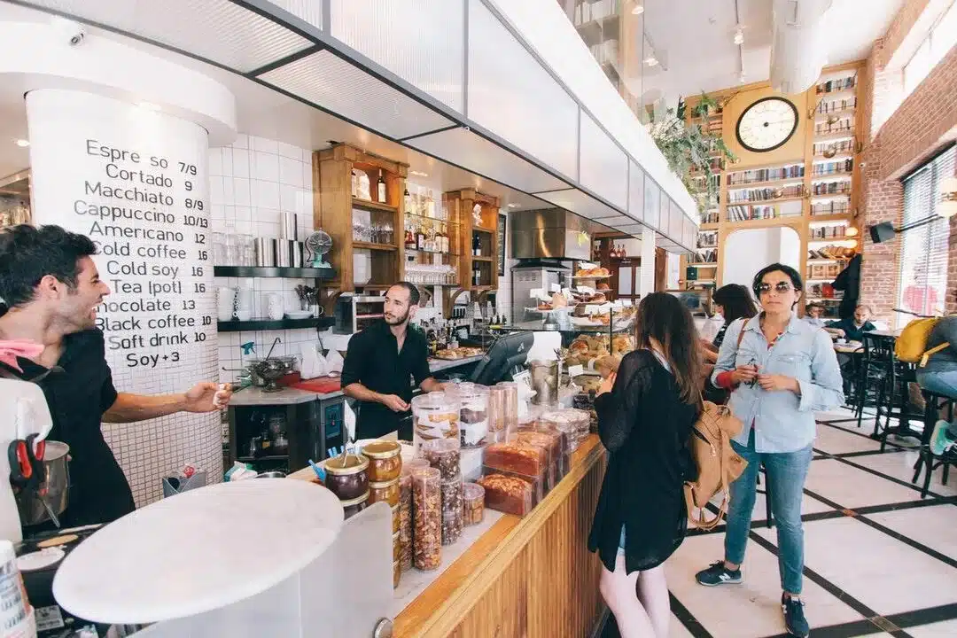 woman-standing-on-food-counter customers being served at food counter